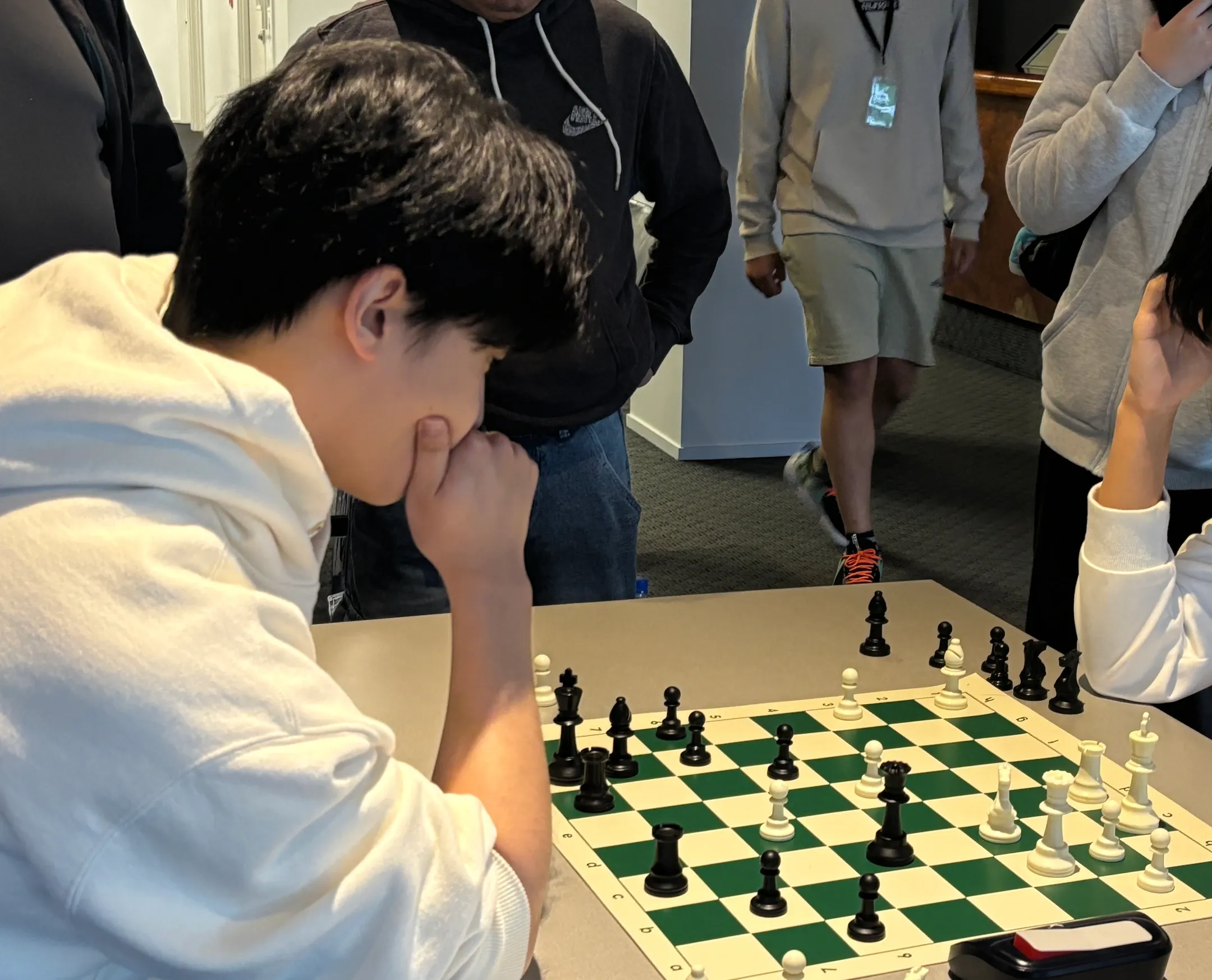 Jeffrey Lin seated at the left side of a chess game, concentrating over most of the board.